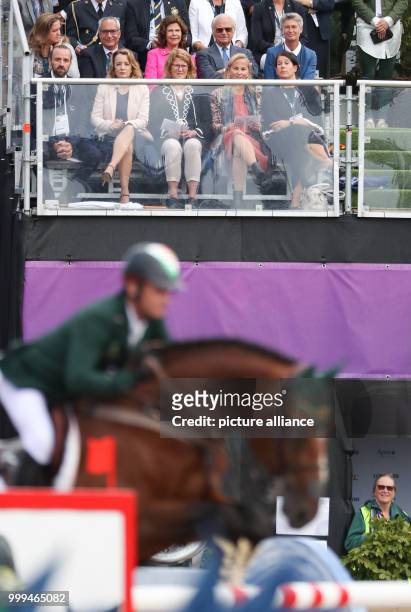 Queen Silvia of Sweden and Carl XVI Gustaf of Sweden sit on the stands during the single show jumping competition of the FEI European Championships...