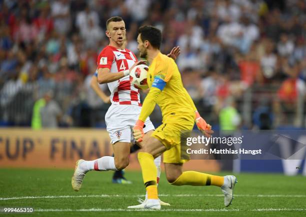 Goalkeeper Hugo Lloris of France controls the ball on his chest outside his penalty area as Ivan Perisic of Croatia closes him down during the 2018...