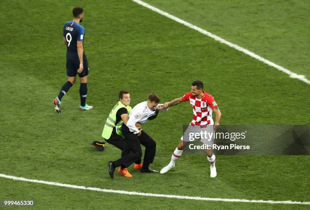 Pitch invader is stopped by Dejan Lovren of Croatia during the 2018 FIFA World Cup Final between France and Croatia at Luzhniki Stadium on July 15,...