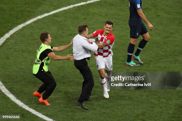 Dejan Lovren of Croatia confronts a pitch invader during the 2018 FIFA World Cup Final between France and Croatia at Luzhniki Stadium on July 15,...