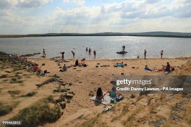People enjoy the weather on England's highest beach, Gaddings Dam, on the outskirts of Todmorden, West Yorkshire, as hot weather continues across the...
