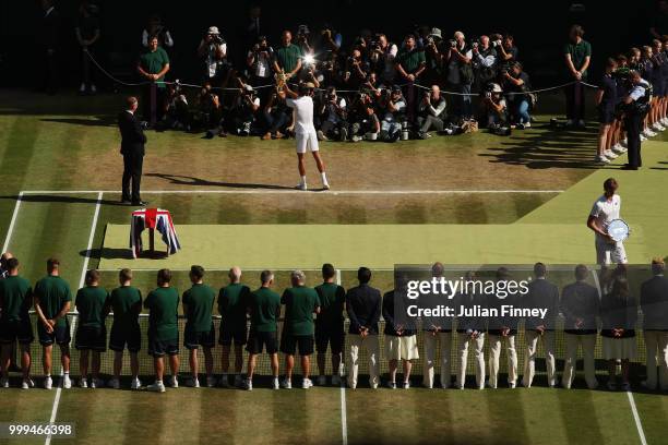 Novak Djokovic of Serbia celebrates with the trophy after winning the Men's Singles final against Kevin Anderson of South Africa on day thirteen of...