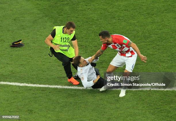 Dejan Lovren of Croatia grabs a pitch invader during the 2018 FIFA World Cup Russia Final between France and Croatia at the Luzhniki Stadium on July...
