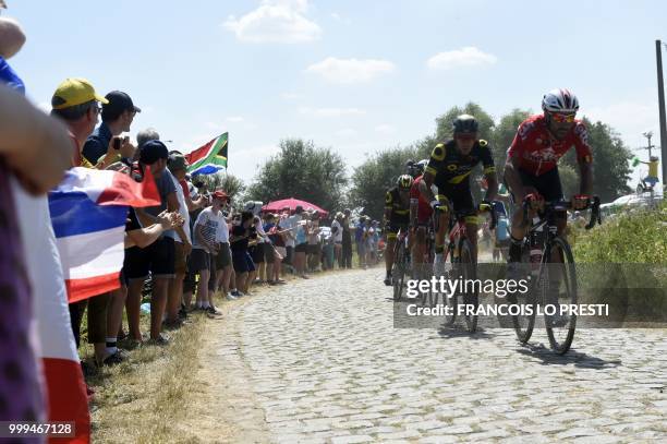 Riders pedal through the stage's fifth cobblestone section between Tilloy and Sars-et-Rosieres during the ninth stage of the 105th edition of the...