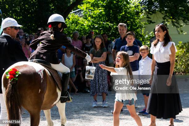 Princess Josephine receives a bucket with candy from a young rider at the Tilting-At-The-Ring Riders Event at Graasten Castle at Graasten on July 15,...