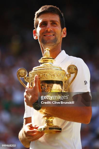 Novak Djokovic of Serbia celebrates with the trophy after winning Men's Singles final against Kevin Anderson of South Africa on day thirteen of the...