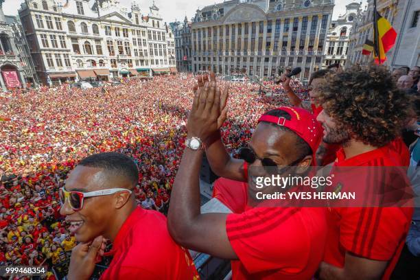 Belgium's midfielder Youri Tielemans , forward Michy Batshuayi and midfielder Marouane Fellaini celebrate at the Grand Place/Grote Markt in Brussels...