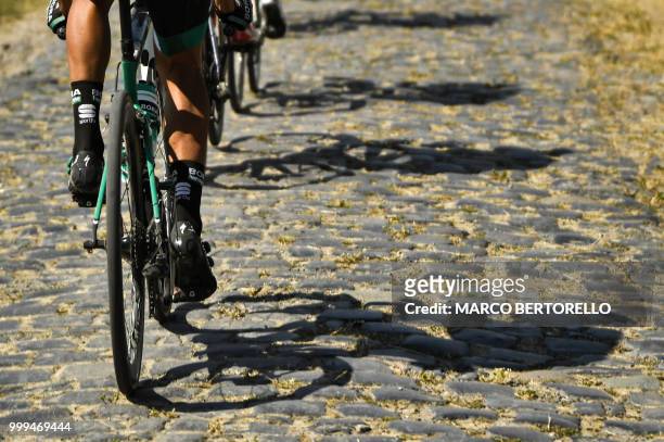 Riders' shadows are cast on cobblestones during the ninth stage of the 105th edition of the Tour de France cycling race between Arras and Roubaix,...