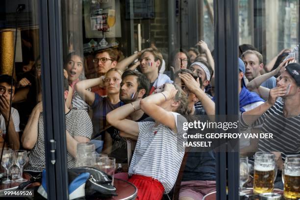 People react as they watch the Russia 2018 World Cup final football match between France and Croatia, in a bar in the Latin Quarter in Paris on July...