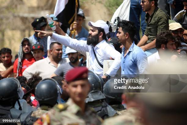 Iraqi citizens shout slogans as they gather to protest against government due to lack of basic services and frequent power outages in front of the...