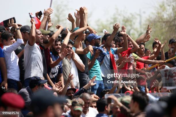 Iraqi citizens shout slogans as they gather to protest against government due to lack of basic services and frequent power outages in front of the...