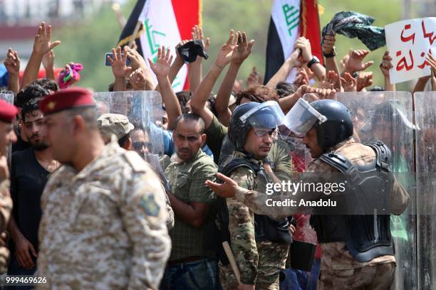 Iraqi security forces take security measures as Iraqi citizens gather to protest government due to lack of basic services and frequent power outages...