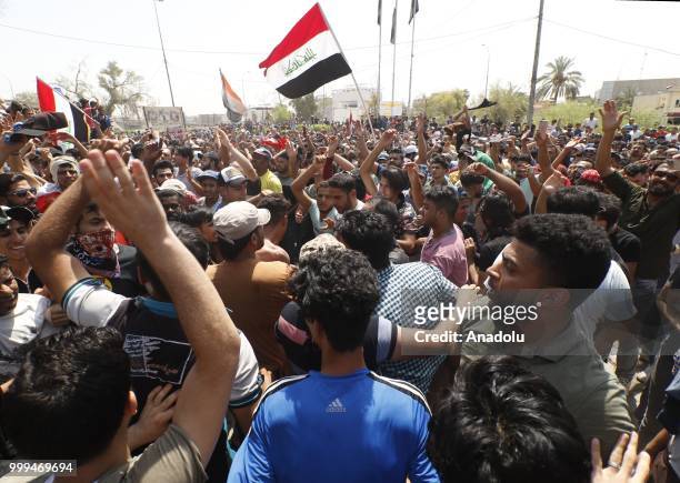 Iraqi citizens shout slogans as they gather to protest against government due to lack of basic services and frequent power outages in front of the...