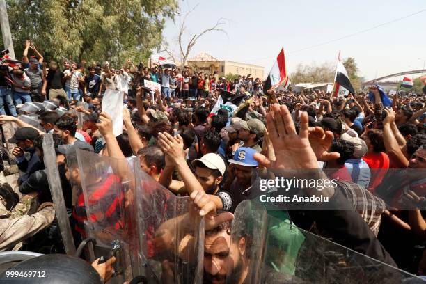 Iraqi citizens shout slogans as they gather to protest against government due to lack of basic services and frequent power outages in front of the...