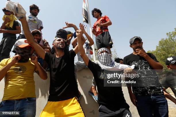 Iraqi citizens shout slogans as they gather to protest against government due to lack of basic services and frequent power outages in front of the...