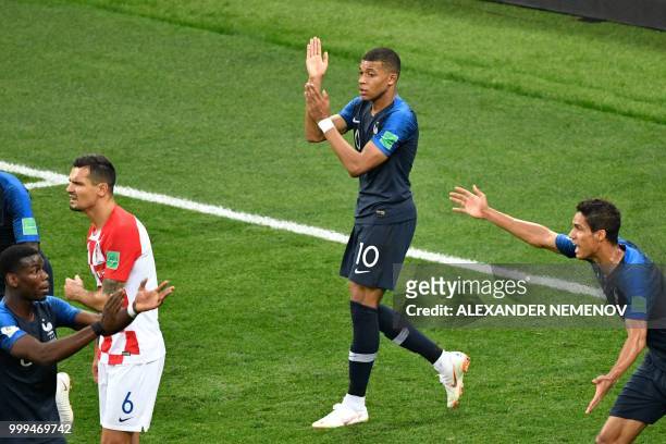 France's forward Kylian Mbappe shows his arm to Argentinian referee Nestor Pitana in order appeal for a hand ball during the Russia 2018 World Cup...