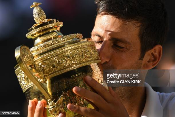 Serbia's Novak Djokovic kisses the winners trophy after beating South Africa's Kevin Anderson 6-2, 6-2, 7-6 in their men's singles final match on the...