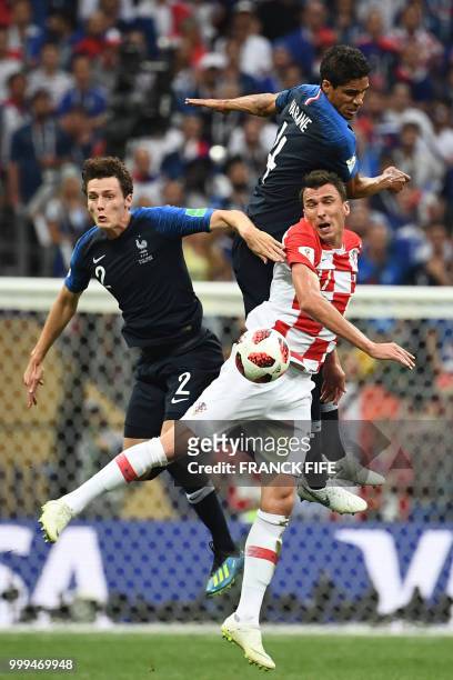 France's defender Raphael Varane and France's defender Benjamin Pavard vie with Croatia's forward Mario Mandzukic during the Russia 2018 World Cup...