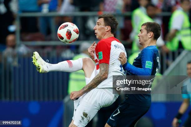 Mario Mandzukic of Croatia and Antoine Griezmann of France battle for the ball during the 2018 FIFA World Cup Russia Final between France and Croatia...