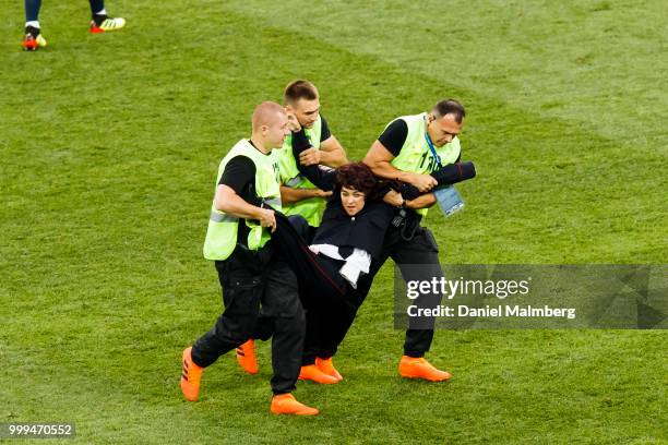 Woman in a Police uniform is carried away from the playing field by three stewards during the 2018 FIFA World Cup Russia Final between France and...
