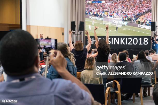People react at the media center in Helsinki as France scores a penalty during the Russia 2018 World Cup final football match between France and...