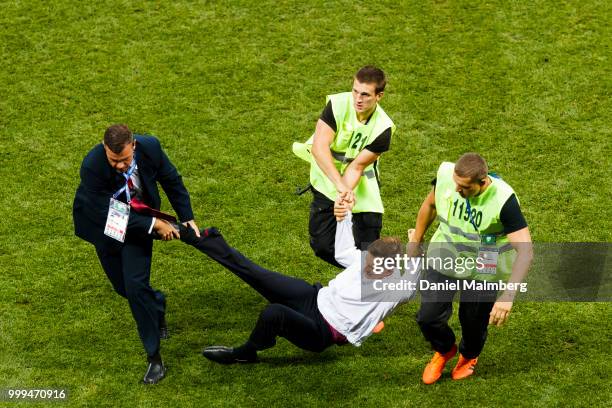 Man is carried away from the playing field by three stewards during the 2018 FIFA World Cup Russia Final between France and Croatia at Luzhniki...