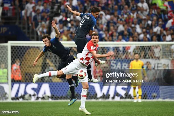 France's defender Raphael Varane and France's defender Benjamin Pavard vie with Croatia's forward Mario Mandzukic during the Russia 2018 World Cup...