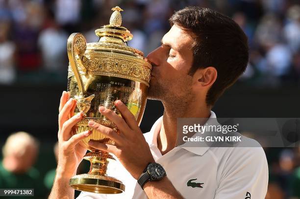 Serbia's Novak Djokovic poses kisses the winners trophy after beating South Africa's Kevin Anderson 6-2, 6-2, 7-6 in their men's singles final match...
