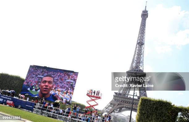 Fans watch Kylian Mbappe on the screen as they watch the FIFA 2018 World Cup final match between France and Croatia at Eiffel tower on July 15, 2018...