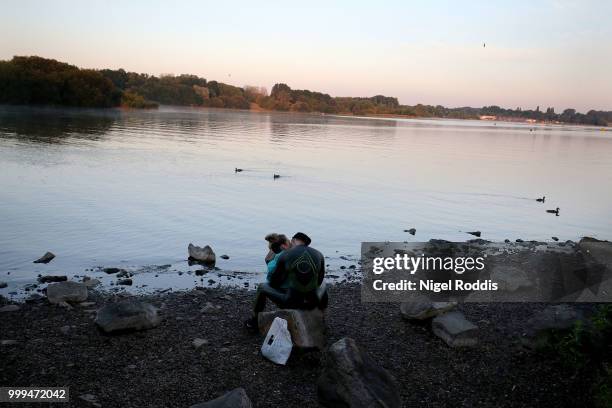 An athlete and his partner sit by the lake ahead of the swim section of Ironman UK on July 15, 2018 in Bolton, England.