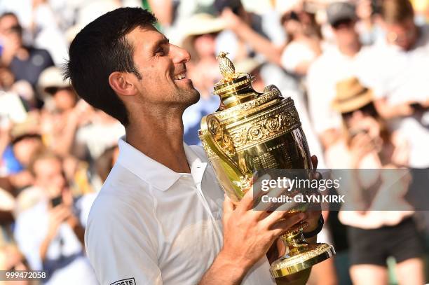 Serbia's Novak Djokovic poses with the winners trophy after beating South Africa's Kevin Anderson 6-2, 6-2, 7-6 in their men's singles final match on...