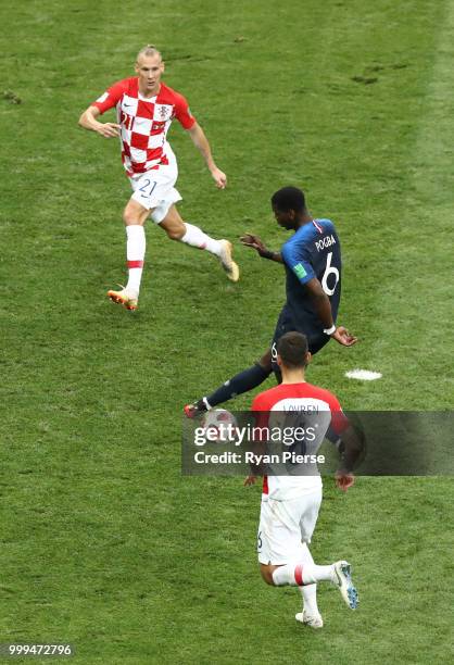 Paul Pogba of France is challenged by Domagoj Vida and Dejan Lovren of Croatia during the 2018 FIFA World Cup Final between France and Croatia at...