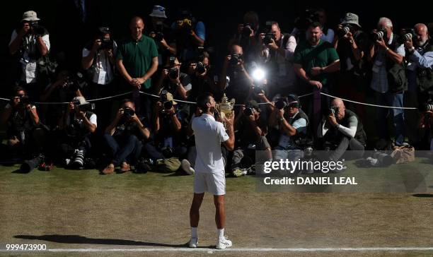 Serbia's Novak Djokovic holds the winners trophy after beating South Africa's Kevin Anderson 6-2, 6-2, 7-6 in their men's singles final match on the...