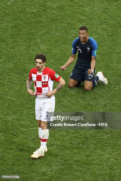 Sime Vrsaljko of Croatia looks dejected as Kylian Mbappe of France celebrates following his sides victory in the 2018 FIFA World Cup Final between...