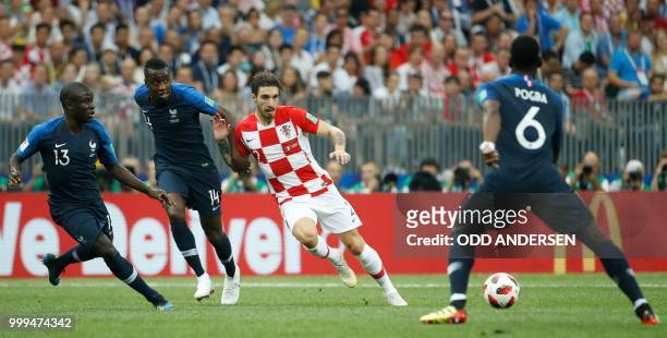 France's midfielder N'Golo Kante, France's midfielder Blaise Matuidi and France's midfielder Paul Pogba vie for the ball with Croatia's defender Sime...