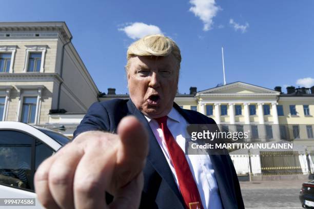 President Donald Trump impersonator Dennis Alan poses for pictures in front of the presidential palace on July 15 ahead of the arrival of US...