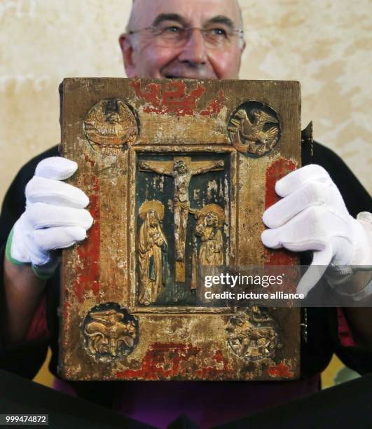 Bishop Felix Genn holds up the Liesborn Evangelion during its official presentation at the Museum Liesborn Abbey in Wadersloh, Germany, 28 August...
