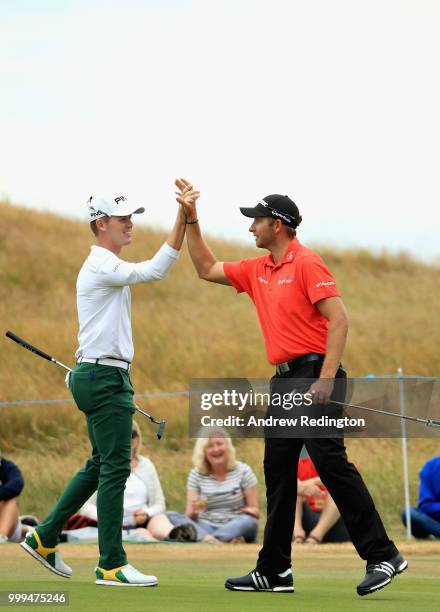 Brandon Stone of South Africa is congratulated for his eagle putt on hole sixteen by Dean Burmester of South Africa during day four of the Aberdeen...