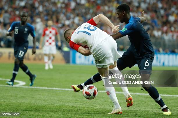 France's midfielder Paul Pogba and Croatia's forward Ante Rebic vie for the ball during the Russia 2018 World Cup final football match between France...