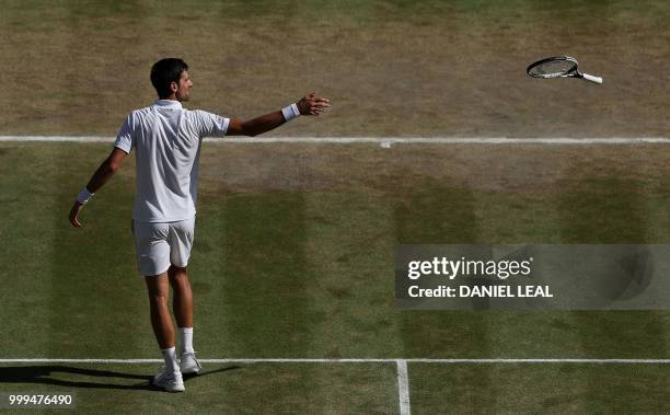 Serbia's Novak Djokovic throws his racket after beating South Africa's Kevin Anderson 6-2, 6-2, 7-6 in their men's singles final match on the...