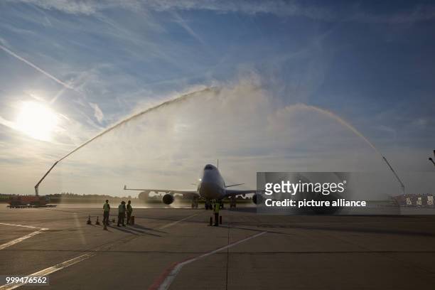An aircraft of the type Boeing 747-400 of the Chinese cargo airline Suparna is being welcomed by the airport fire department with a jet of water at...