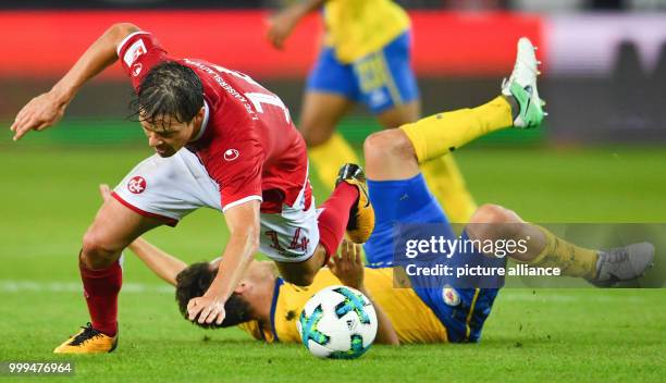 Dpatop - Kaiserslautern's Mads Albaek stumbles over Braunschweig's Mirko Boland during the German Second Bundesliga soccer match between 1. FC...