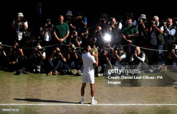 Novak Djokovic holds the trophy after winning the Gentlemen's Single Final against Kevin Anderson on day thirteen of the Wimbledon Championships at...