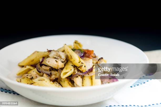 pasta with pesto sauce and nuts on a the table - pesto stock pictures, royalty-free photos & images