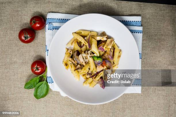 pasta with pesto sauce and nuts on a the table - pesto stock pictures, royalty-free photos & images