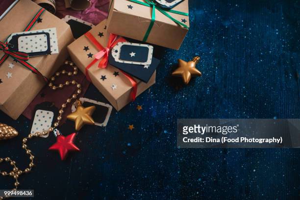 decorations and wrapped presents concept. christmas celebration dark flat lay with craft paper... - business flat lay stock pictures, royalty-free photos & images