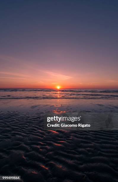 the first light of sunrise on the beach of caorle - caorle stock-fotos und bilder