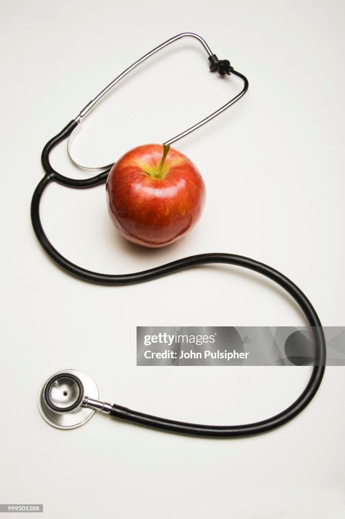 Stethoscope and red apple, concept An apple a day keeps the doctor away