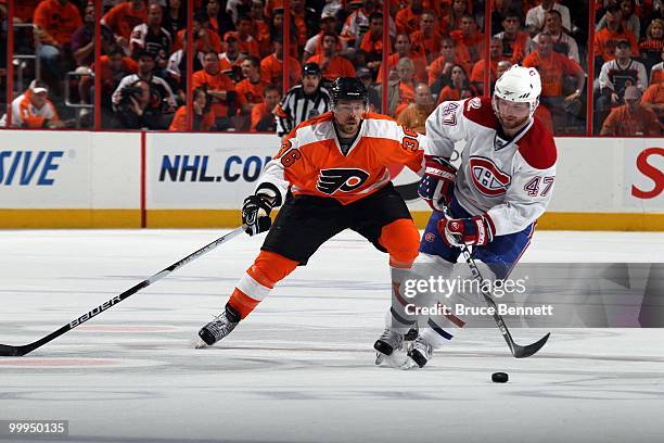 Marc-Andre Bergeron of the Montreal Canadiens handles the puck against Darroll Powe of the Philadelphia Flyers in Game 1 of the Eastern Conference...