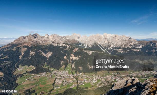 view from the top of the cima dodici, sas da le doudesh in the val san nicolo di fassa, behind the rosengartengruppe massif, below the fassa valley with the village of vigo di fassa and pozza di fassa, dolomites, trentino province, trentino-alto adige - alto stock pictures, royalty-free photos & images